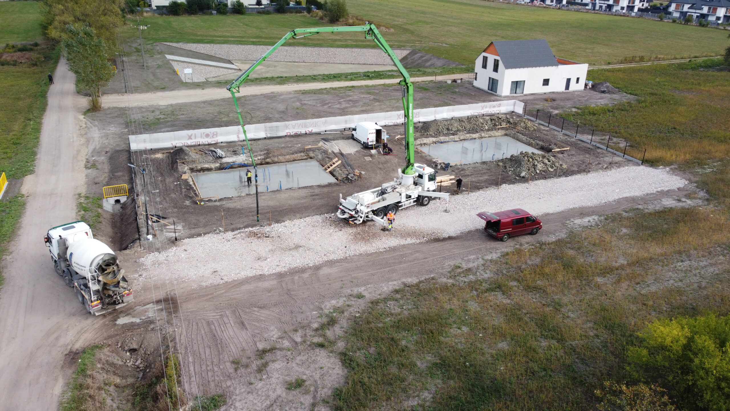 Wykonanie płyt fundamentowych dwóch budynków dwulokalowych – ujęcie z góry podczas betonowania.