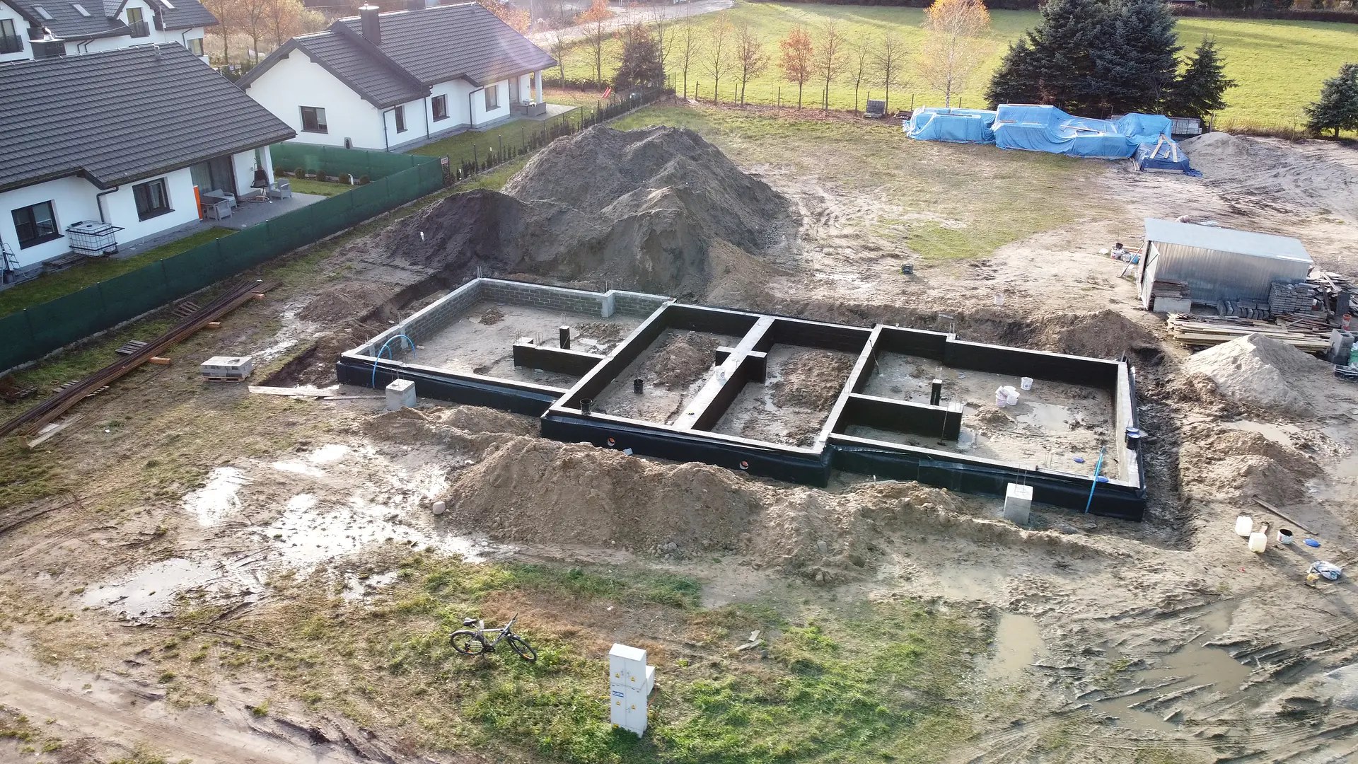 Ściany fundamentowe po wykonaniu izolacji przeciwwilgociowej – etap stanu zero, 4 listopada 2025 r.
